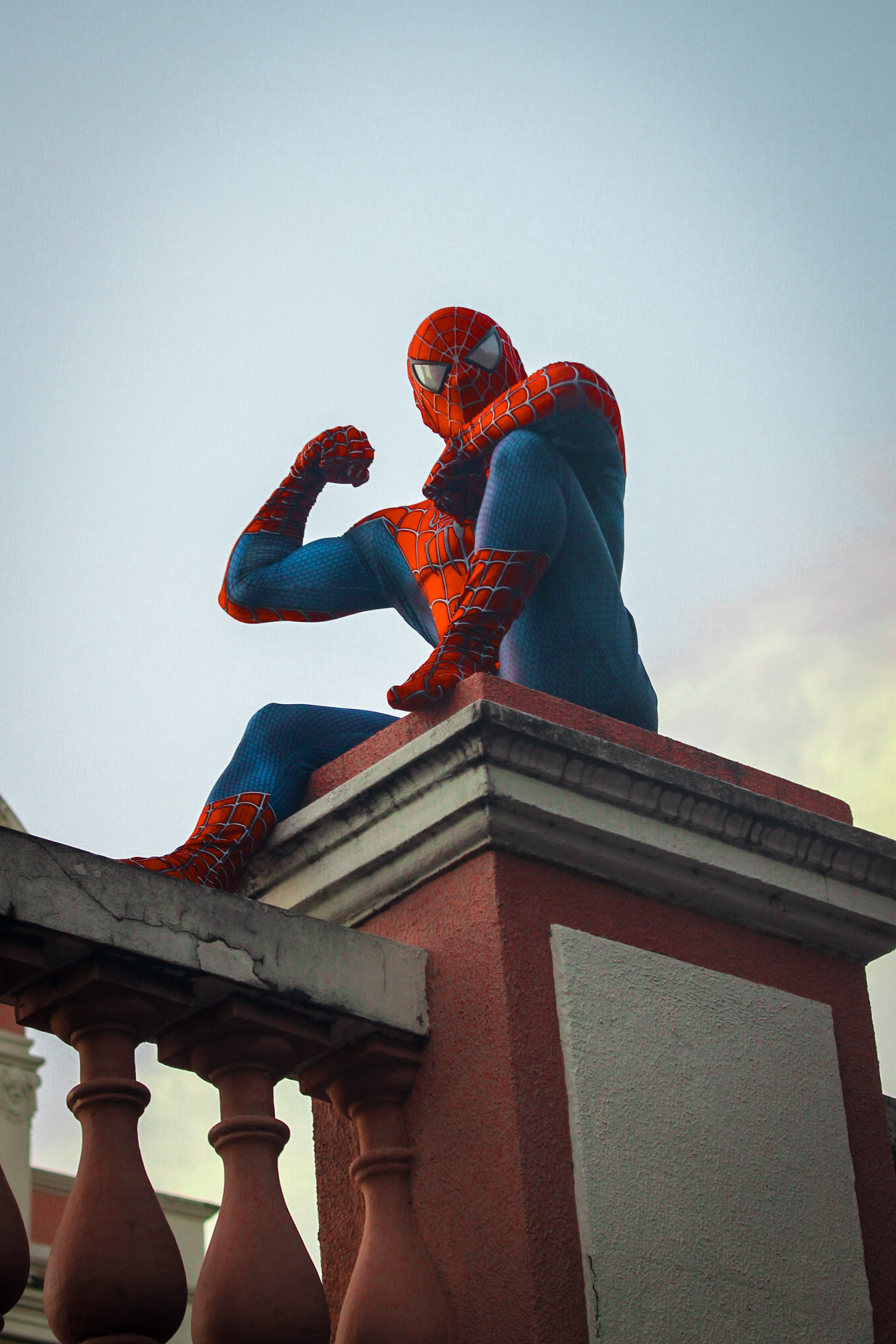 Charles Bezerra como Homem-Aranha sobre pilar de sacada